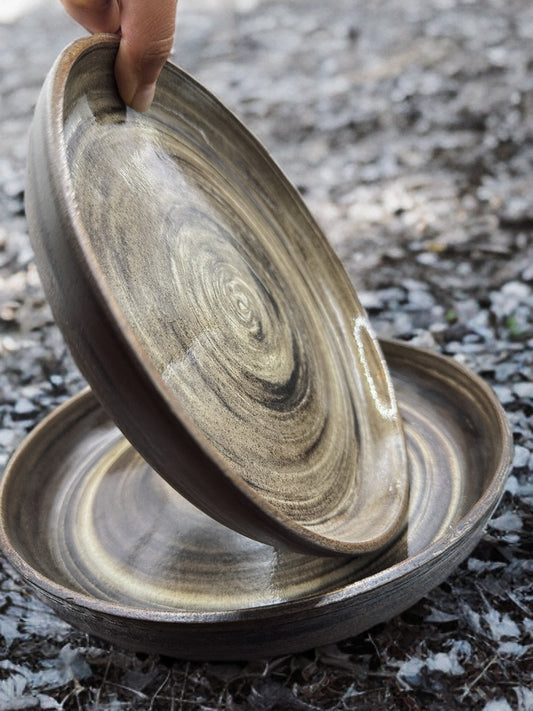 Stack of wooden bowls with concentric circle patterns on a textured surface